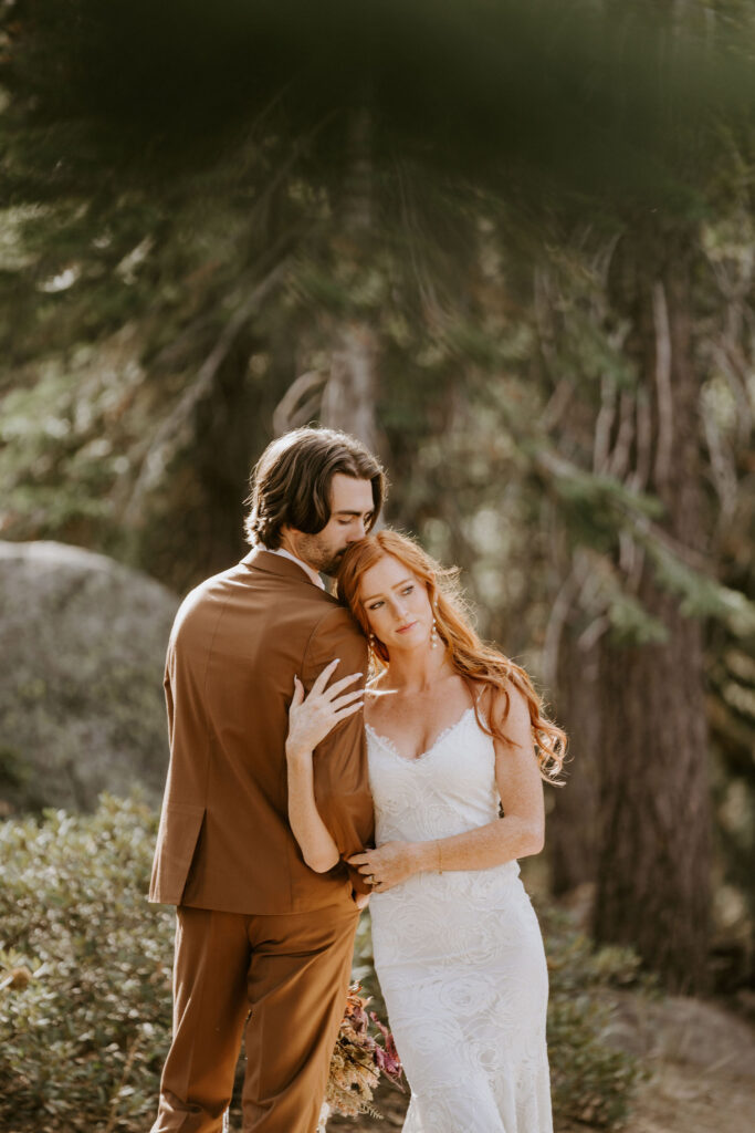groom kissing the bride on the forehead during their photoshoot
