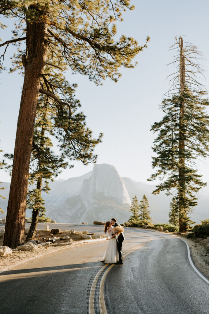 glacier point road couple kissing at sunrise on wedding day in Yosemite