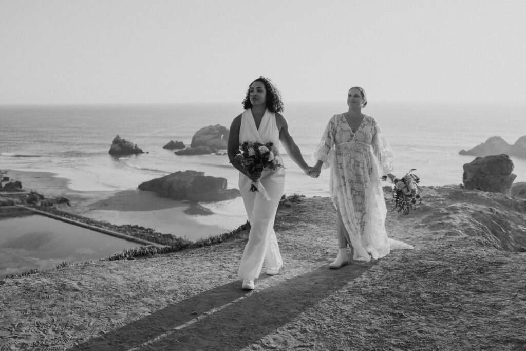 black and white of couple walking above sutro baths in san francisco