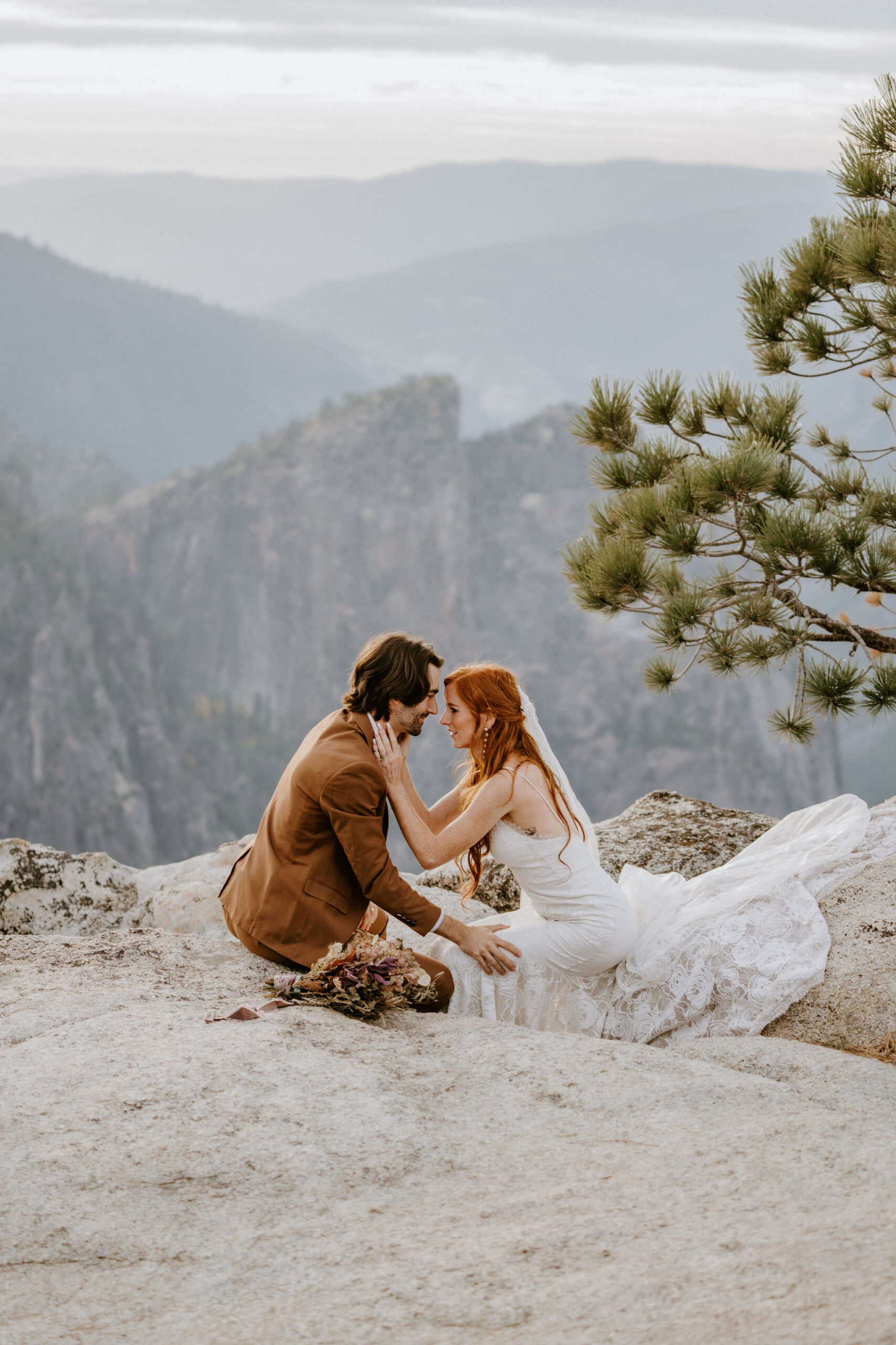 couple sits on edge of yosemite