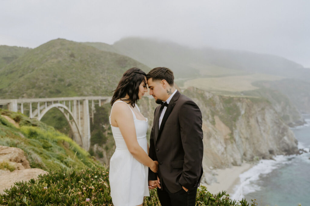 couple posing in front of bixby bridge in big sur
