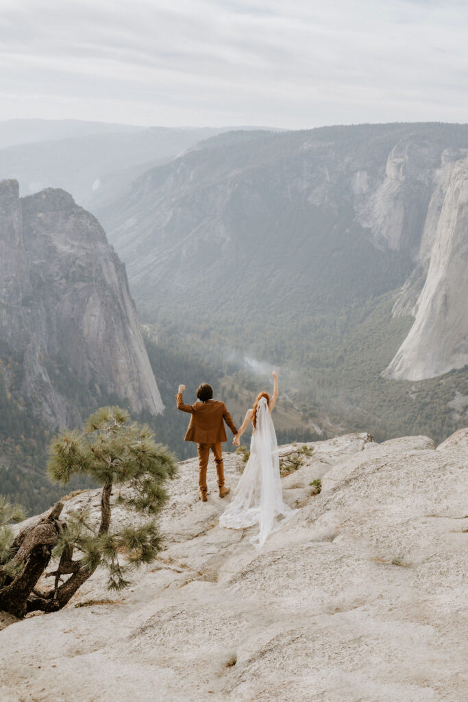 couple cheering after eloping at Taft Point in Yosemite