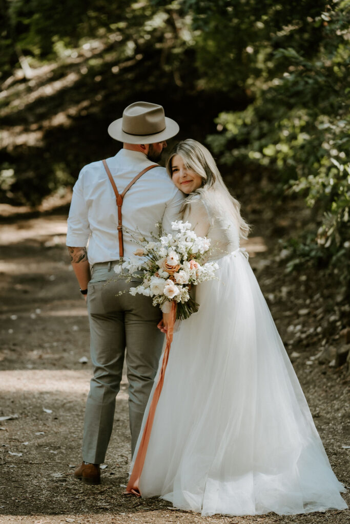 bride looking back walking into redwood forest