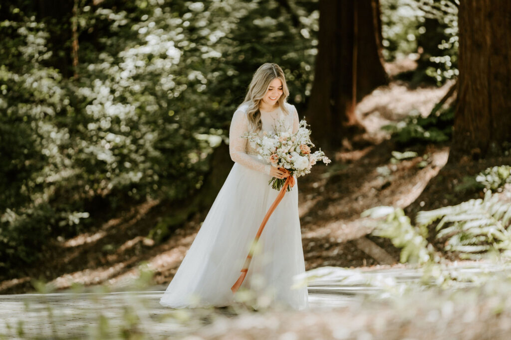 california redwood forest elopement with bride walking with flowers