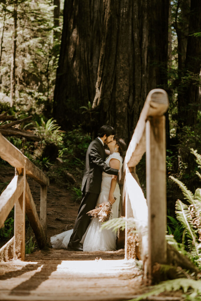 california redwood forest elopement couple kissing on bridge