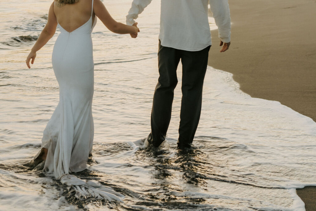 adventure bride and groom wading in the water on their elopement night