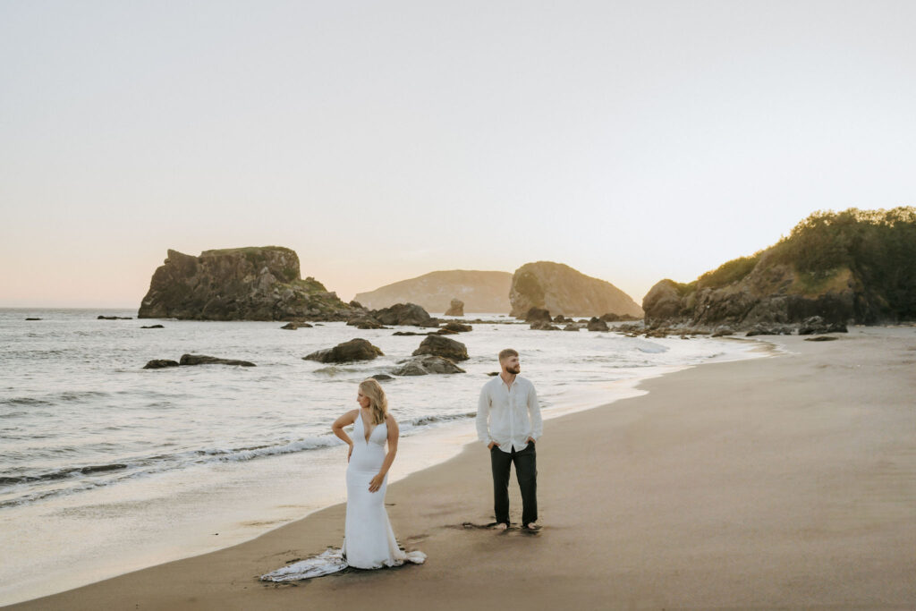 Oregon Coast elopement couple at sunset on the beach posing for portraits