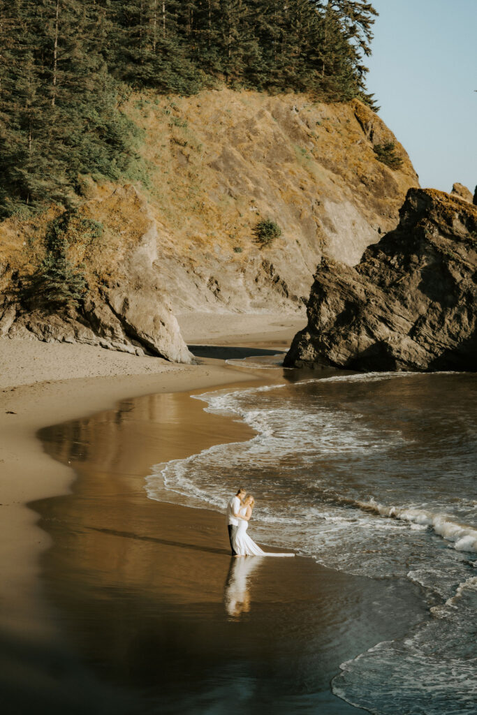 eloping couple kissing on the beach