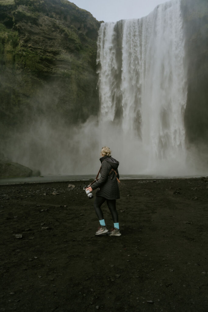 iceland elopement photographer walking towards waterfall