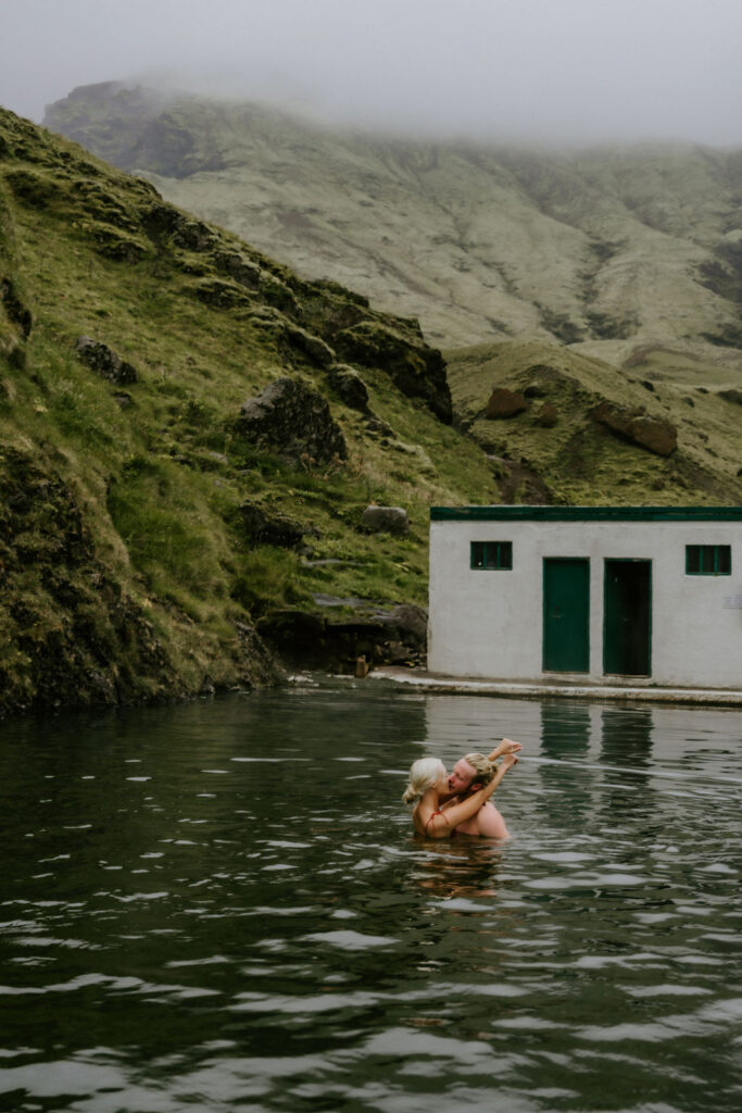 eloping coupling adventure couple enjoyin gthe water at Seljavallalaug in iceland