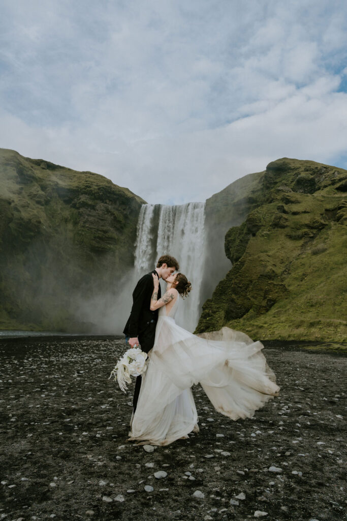 adventure elopement destination couple kissing in front of skogafoss waterfall in iceland