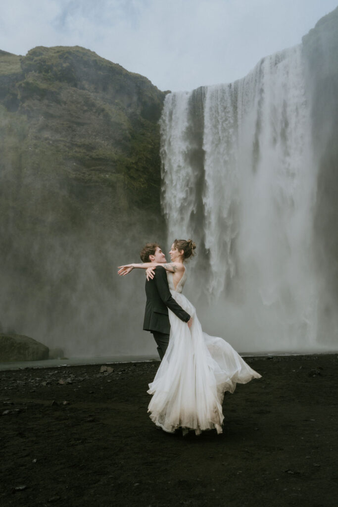 couple enjoying embrace at skogafoss waterfall iceland on elopement day