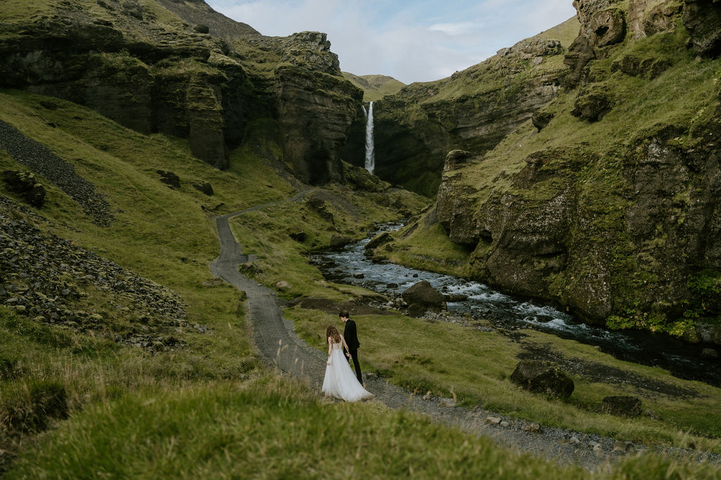 iceland elopement couple walking toward waterfall