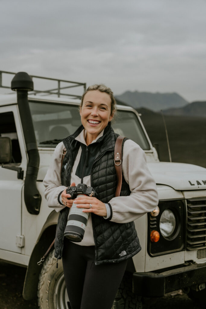 photographer in iceland standing in front of super jeep