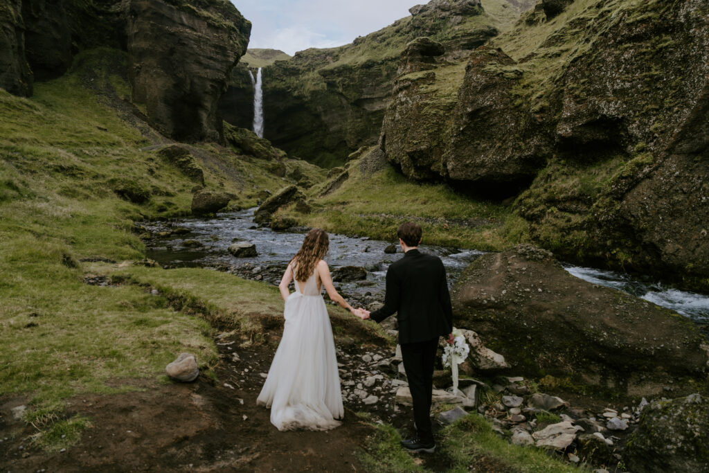 couple hiking to waterfall on elopement in Iceland