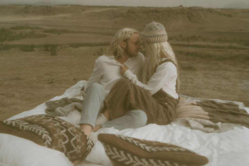 casual couple cozying up in panorama glass lodge in iceland