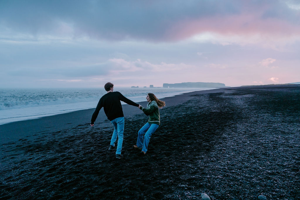 couple enjoying the sunset on black sand beaches of iceland