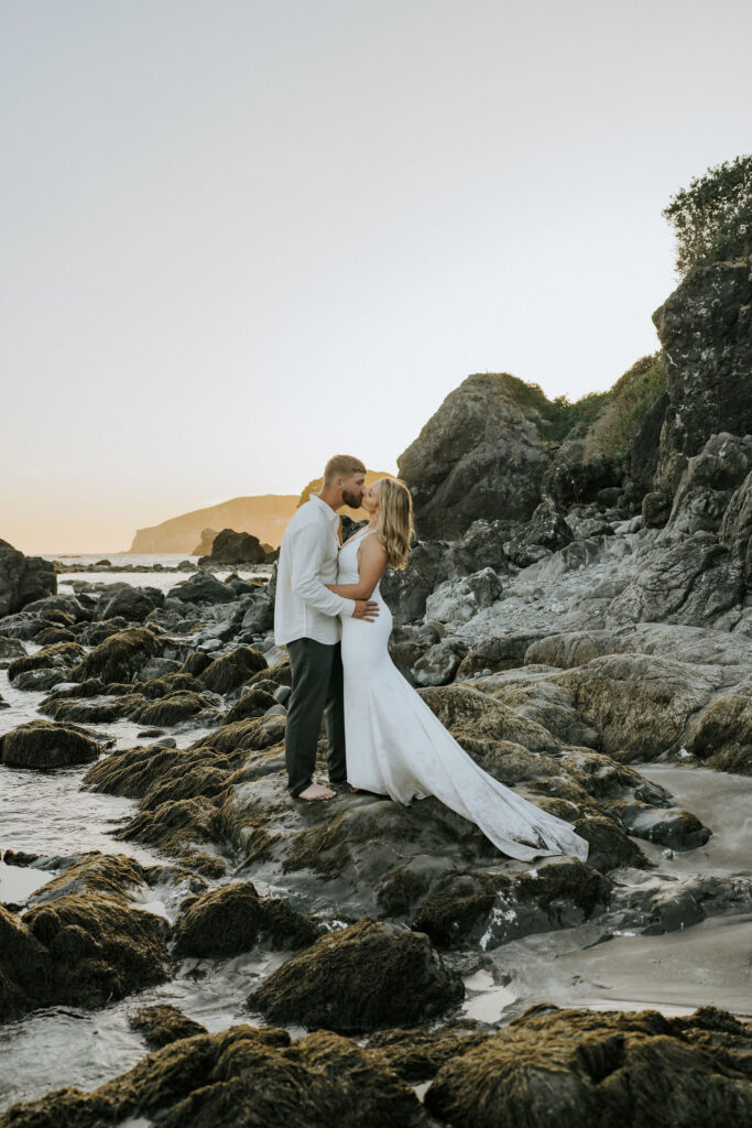 bride and groom kissing at sunset