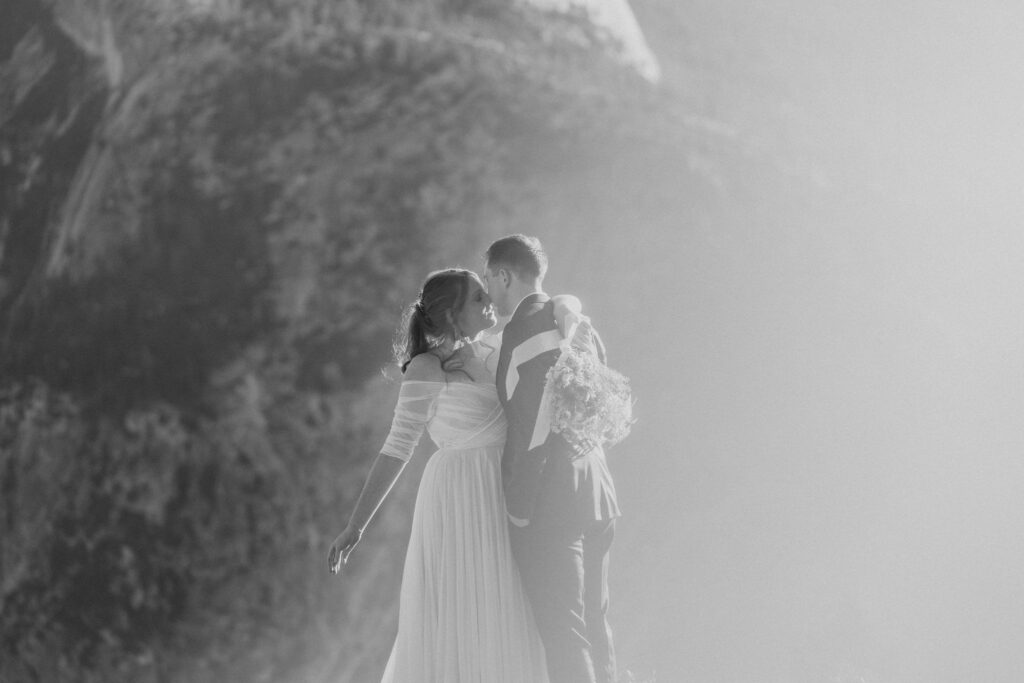 black and white of bride and groom kissing