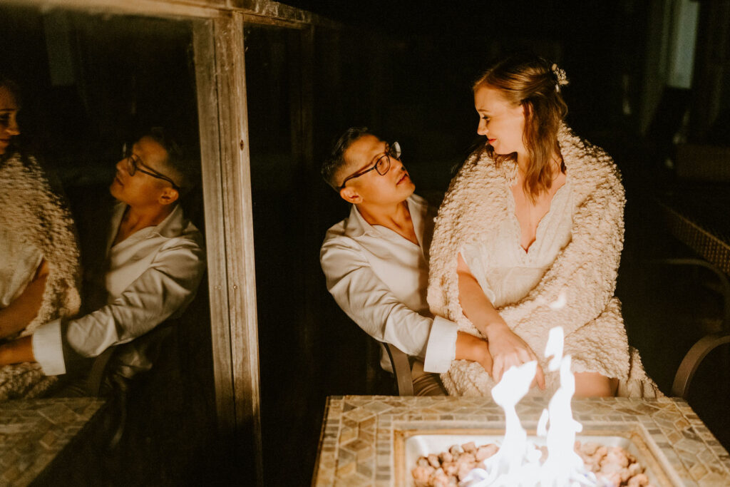 bride and groom sitting cozy by open fire