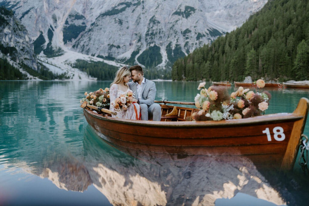 dreamy elopement couple on a classic rowboat in lago di braies