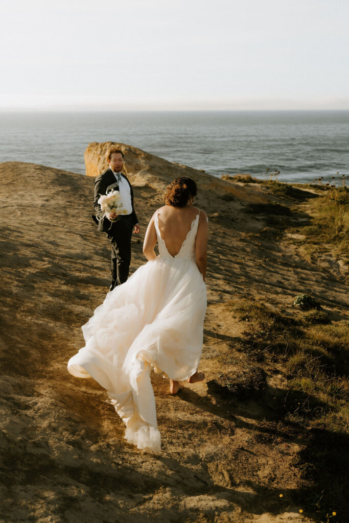 adventurous elopement couple climbing rock stacks during their cannon beach elopement