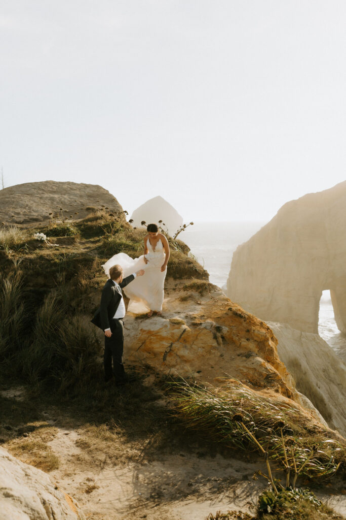 adventurous elopement couple climbing rock stacks during their cannon beach elopement