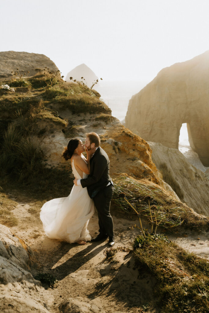 adventurous elopement couple climbing rock stacks during their cannon beach elopement