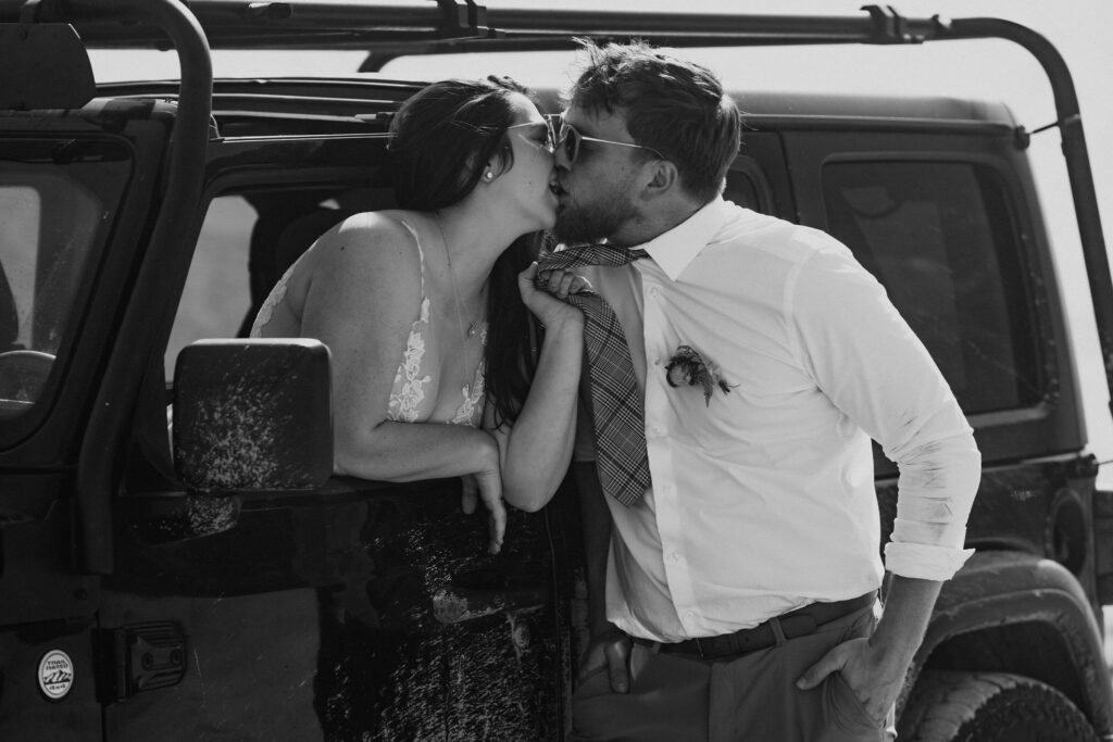 bride and groom kissing in a jeep