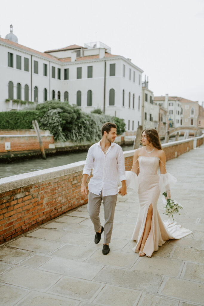 elopement couple walking along the water in venice