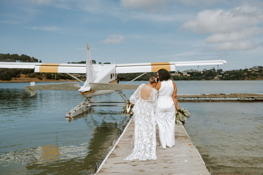 lgbtq couple heading towards a little white seaplane