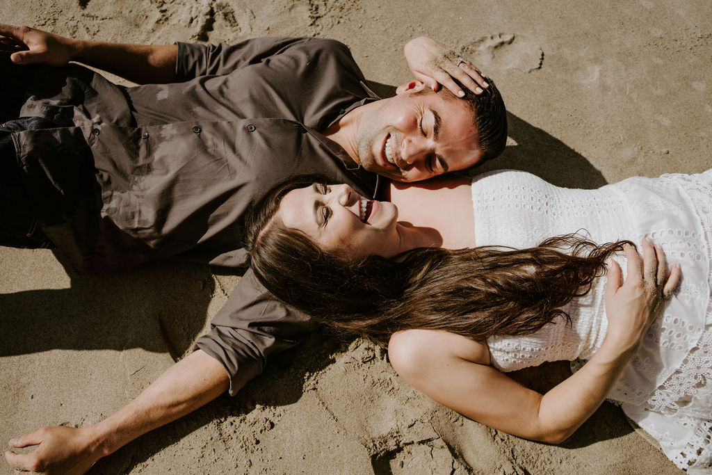 bride and groom sleeping in the sand at the beach during their southern california elopement