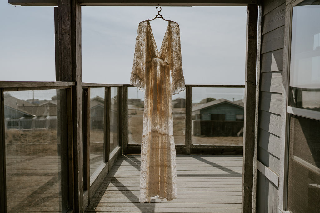 boho elopement dress hanging on the balcony at their airbnb