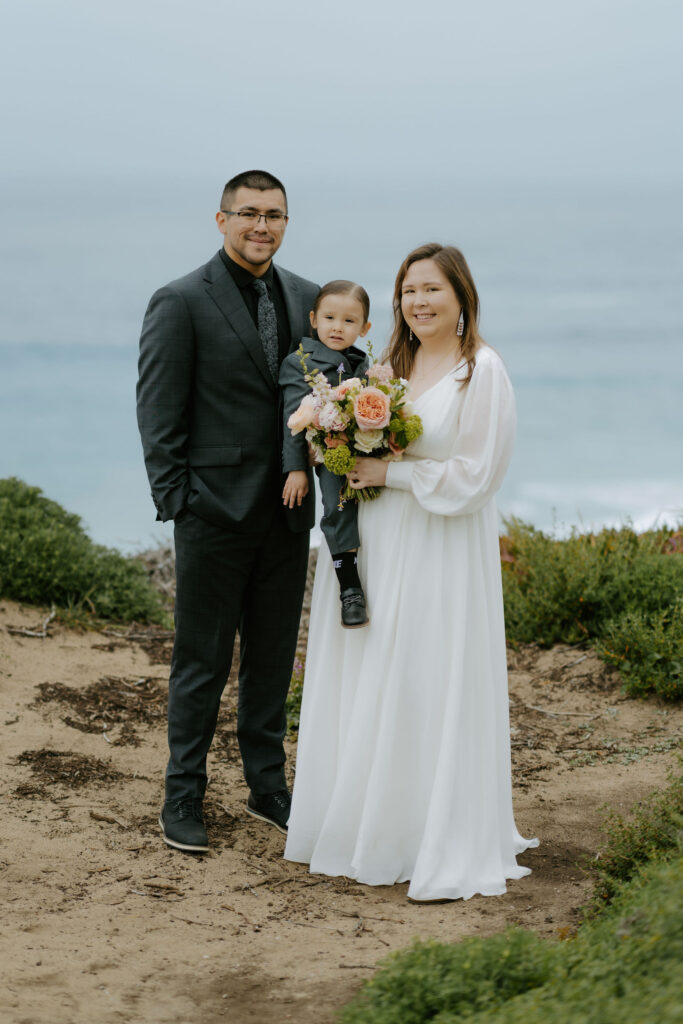 sweet big sur elopement couple with their little boy at garrapata beach overlook