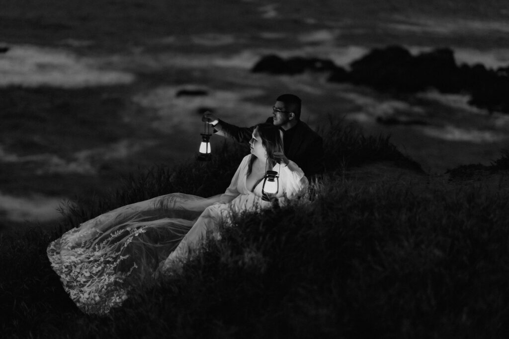 elopement couple sitting with lanterns along Big Sur coast
