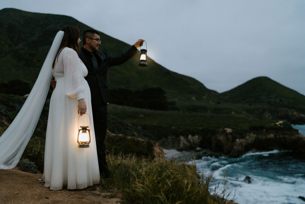 elopement couple hiking with lanterns along Big Sur coast