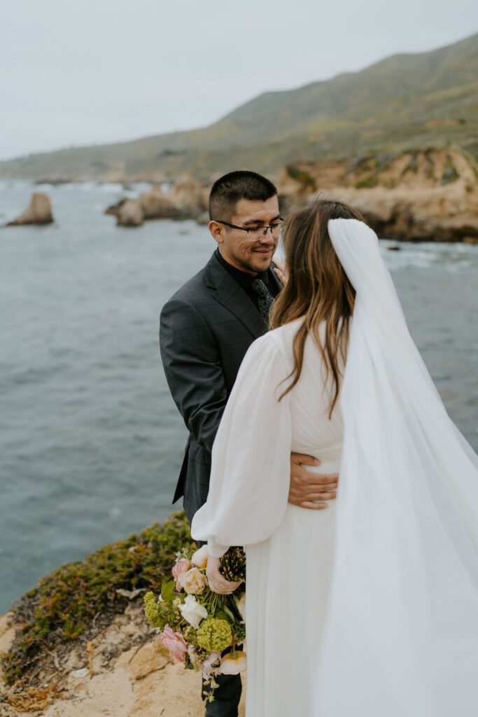 bride and groom on a cliff at Big Sur