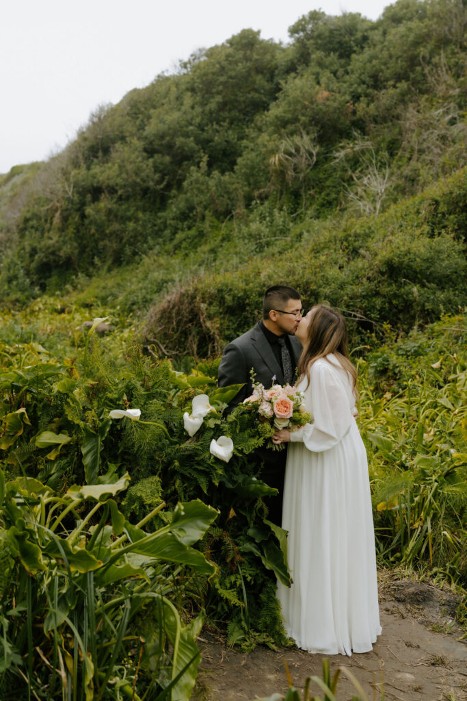 bride and groom kissing in Calla Lily Valley