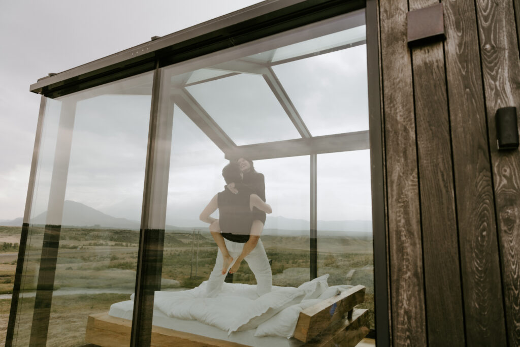 playful couple in bed at Panorama Glass Lodge in Icelandic Highlands