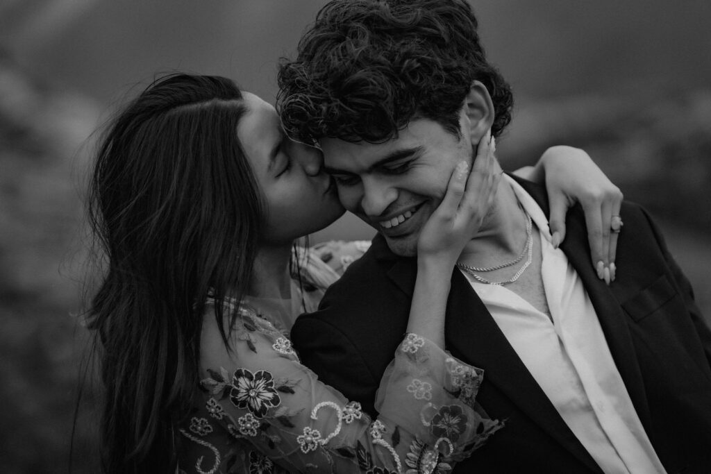 close up of bride kissing groom on the cheek