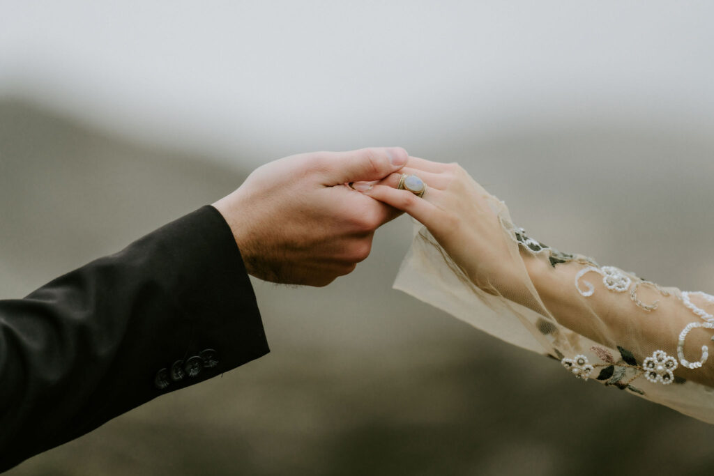 close up of bride and groom holding hands