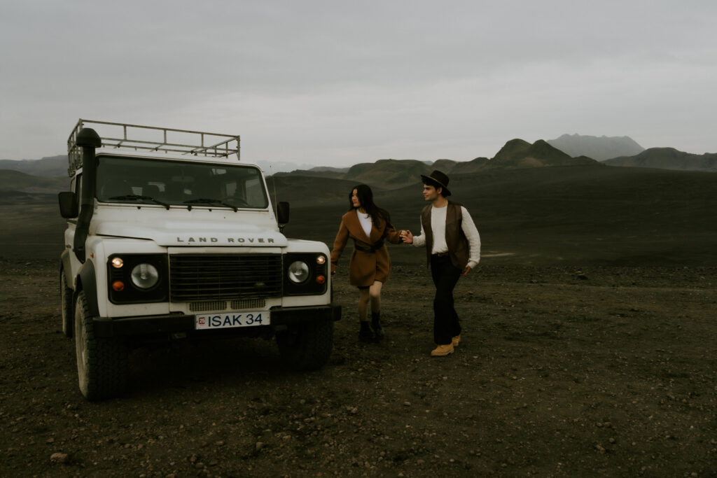 sweet couple posing next to the jeep during their highlands elopement in iceland