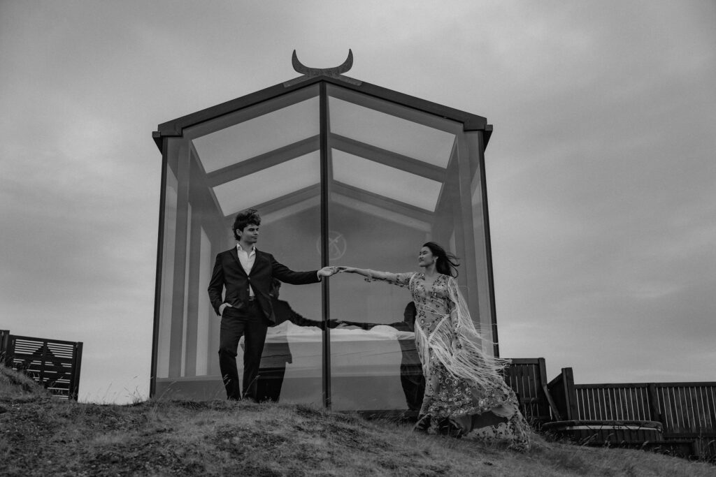 Elopement couple holding hands outside Panorama Glass Lodge in Iceland