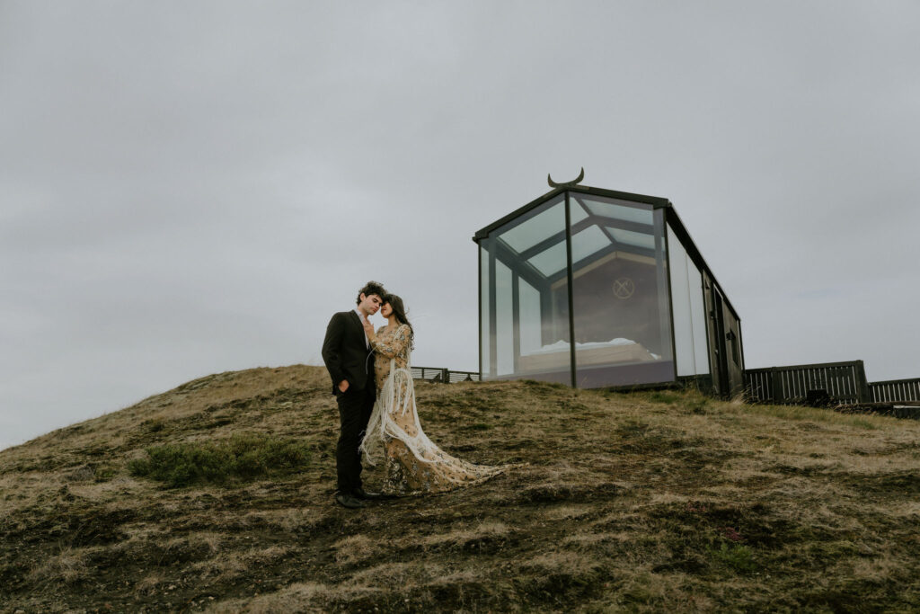 Elopement couple hugging outside Panorama Glass Lodge in Iceland