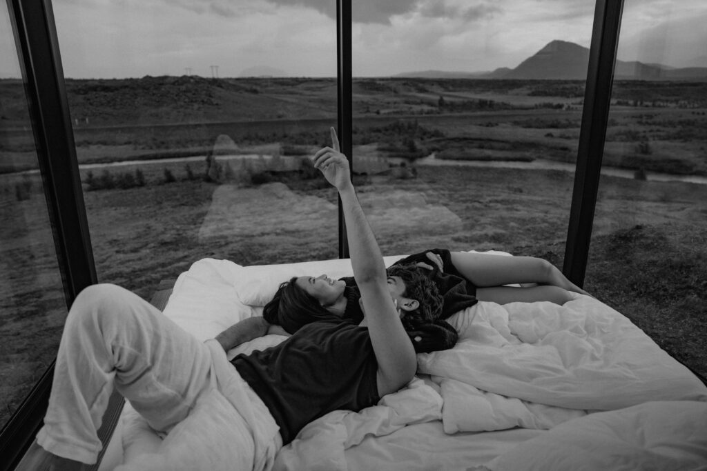 playful couple in bed at Panorama Glass Lodge in Icelandic Highlands
