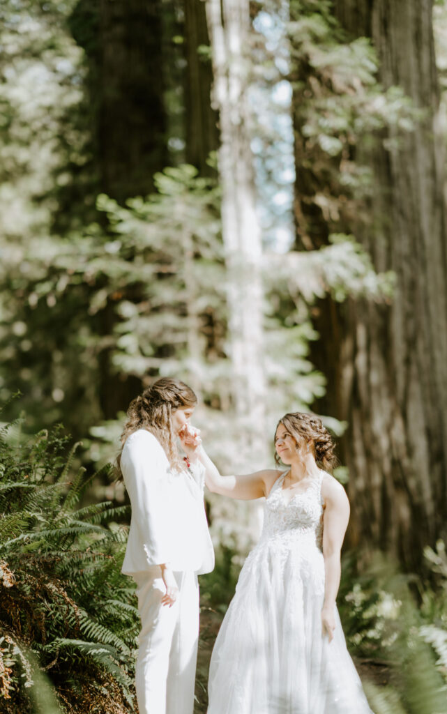 brides hiking through the forest together during their redwoods elopement
