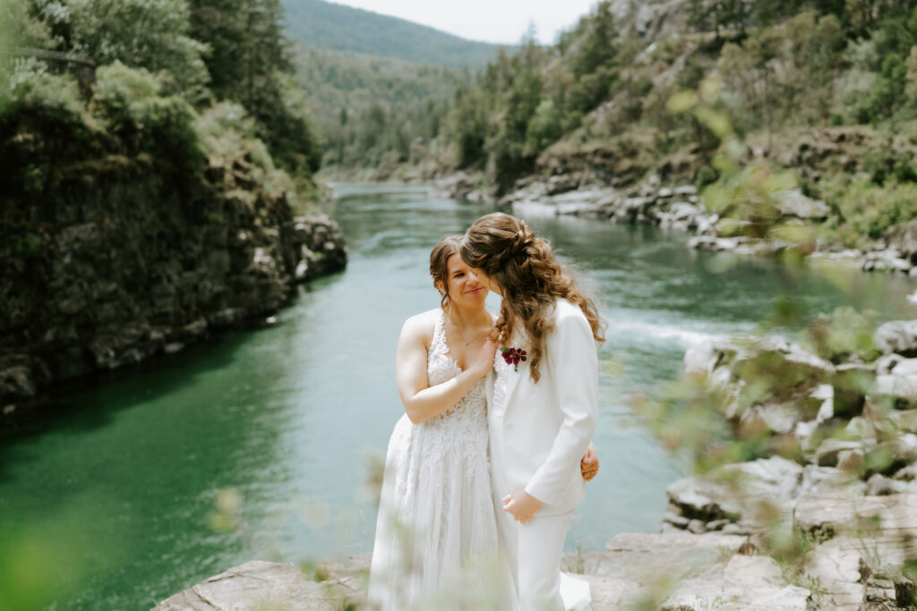 lgbtq couple standing on a rocky hill overlooking smith river