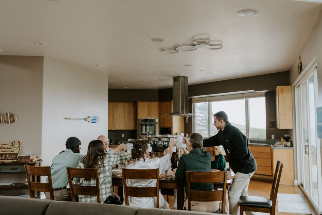 excited family celebrating over lunch with the beautiful elopement couple 