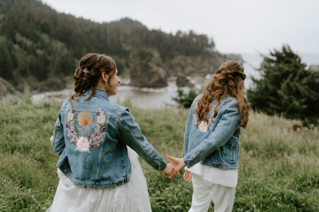 brides walking hand in hand around oregon coast at secret beach