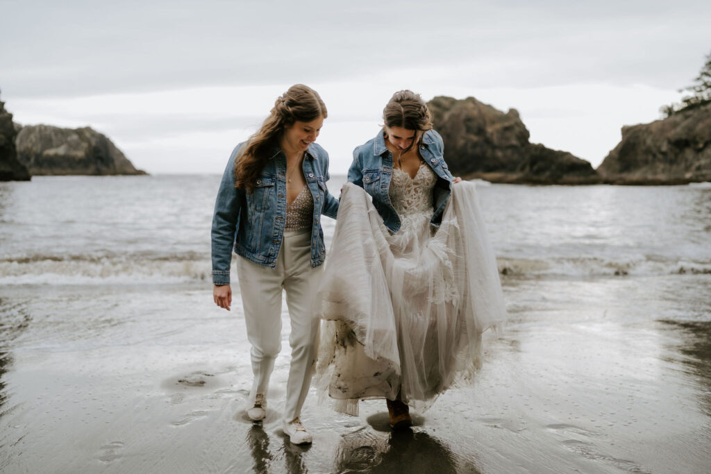 brides walking hand in hand around oregon coast at secret beach
